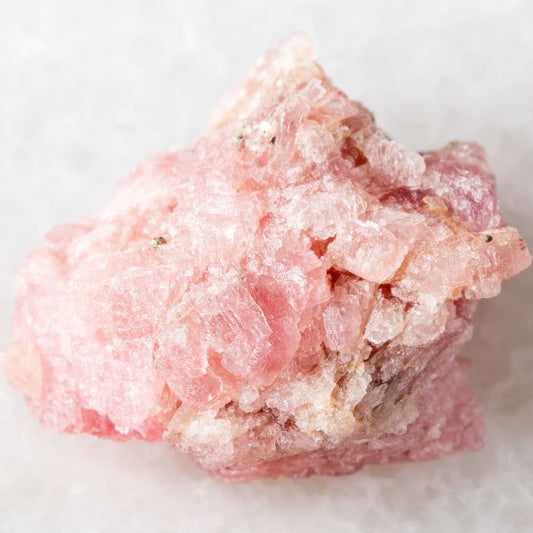 Grosse druse de quartz rose utilisée en lithothérapie, présentée en gros plan dans un guide sur l’entretien et la purification des pierres.