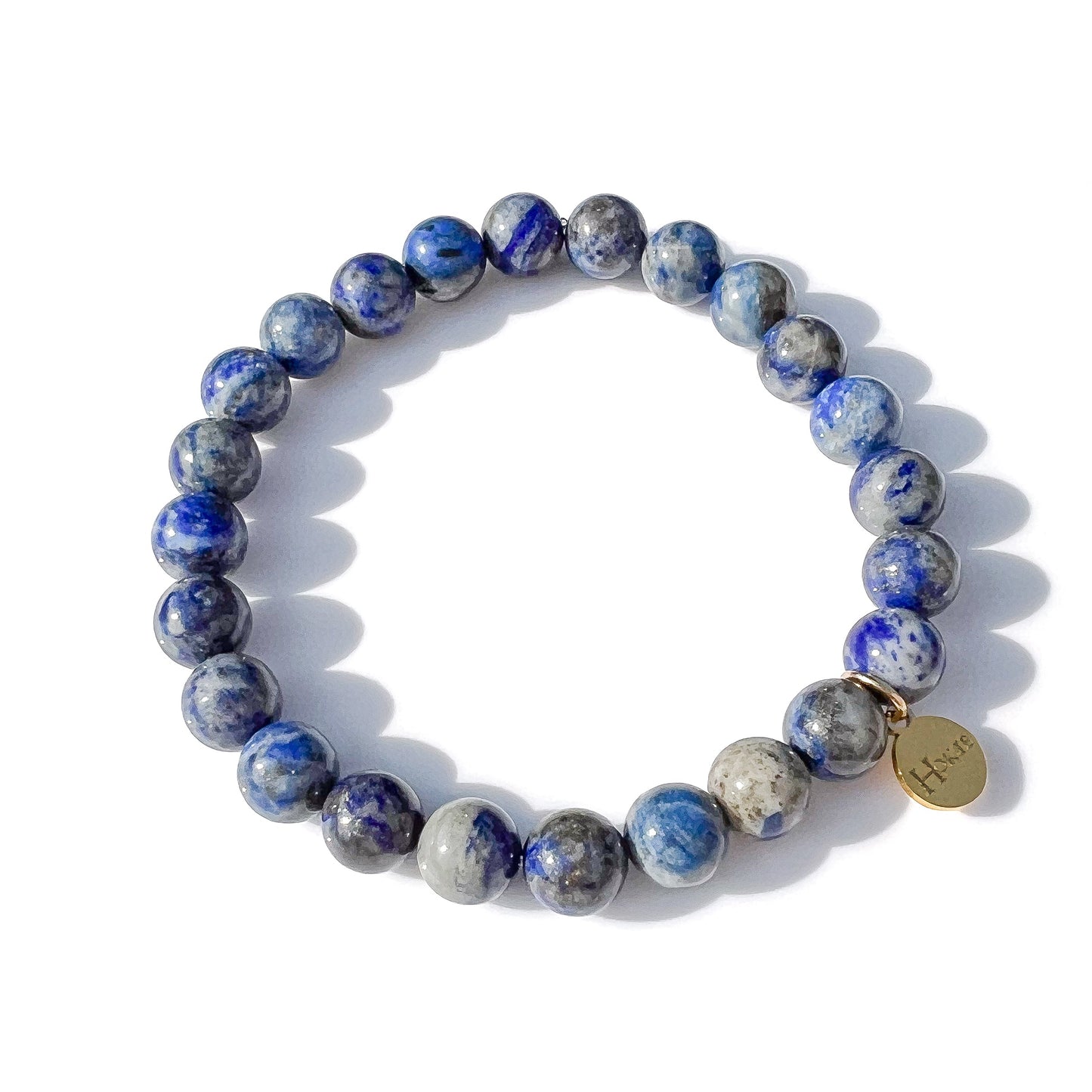 Bracelet en pierres naturelles de lapis-lazuli aux reflets bleus profonds et gris argenté, symbole de sagesse, d’intuition et de clarté mentale, orné d’un médaillon doré gravé  Hokee