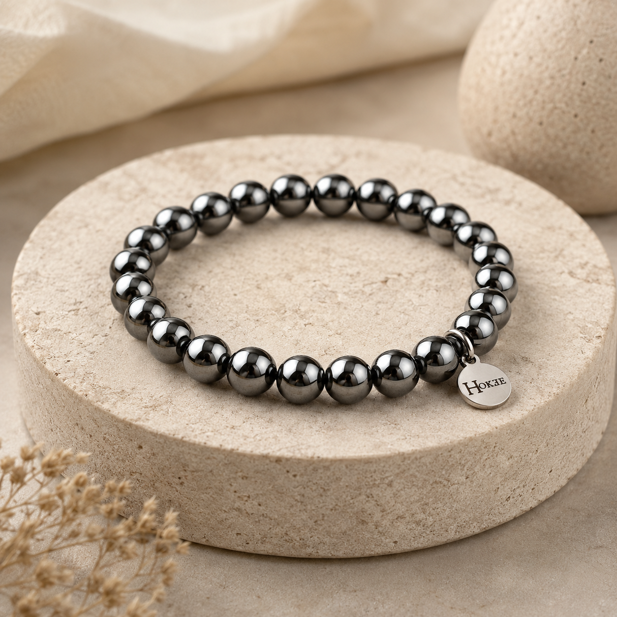 Bracelet en magnétite naturelle 8 mm posé sur un socle élégant HOKEE